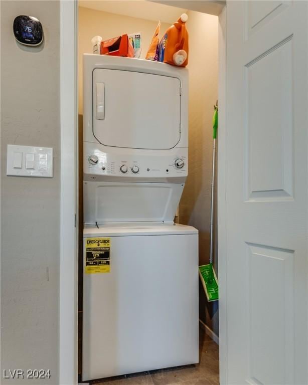 clothes washing area featuring stacked washer and dryer and laundry area