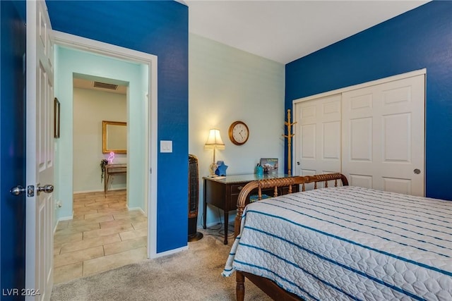 bedroom featuring a closet, light colored carpet, visible vents, and baseboards