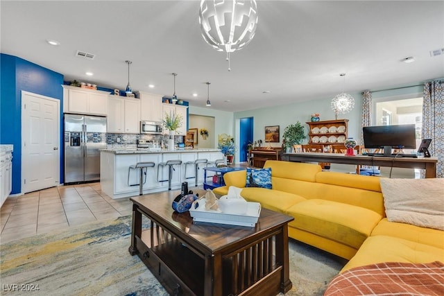 living area featuring visible vents, an inviting chandelier, and light tile patterned floors