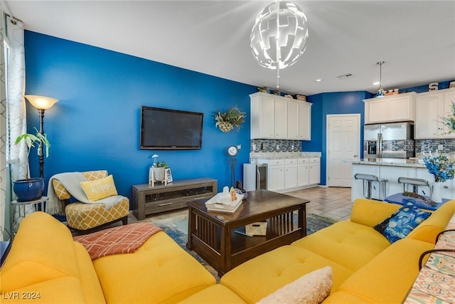 living area with light tile patterned floors, visible vents, and a chandelier