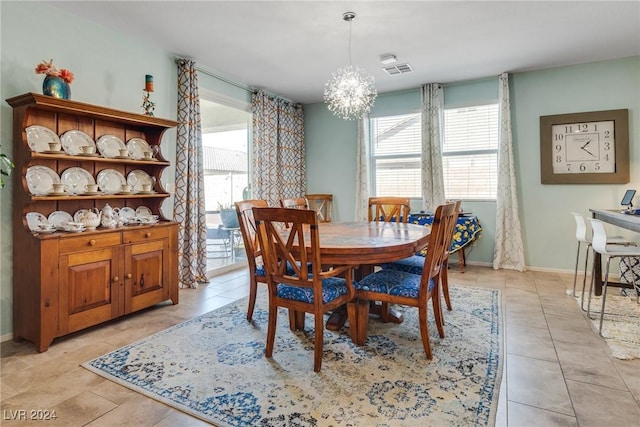 dining space with plenty of natural light, visible vents, a chandelier, and baseboards