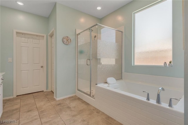 full bath featuring a stall shower, a garden tub, baseboards, and tile patterned floors