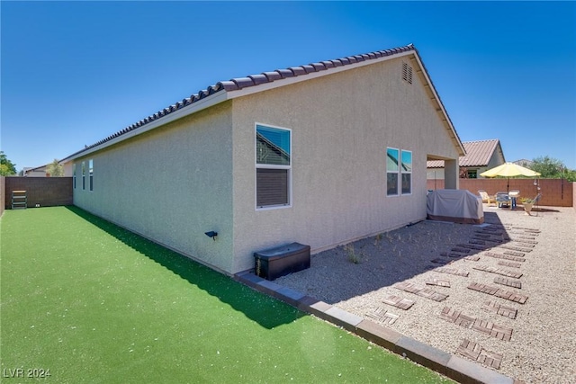 back of house with a patio area, a fenced backyard, a tile roof, and stucco siding