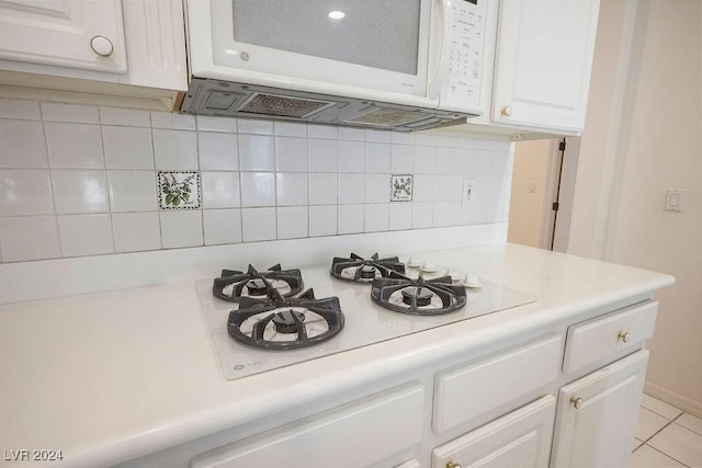 room details featuring light countertops, white appliances, and white cabinets