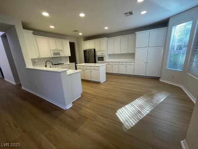 kitchen with visible vents, stainless steel appliances, light countertops, and white cabinetry