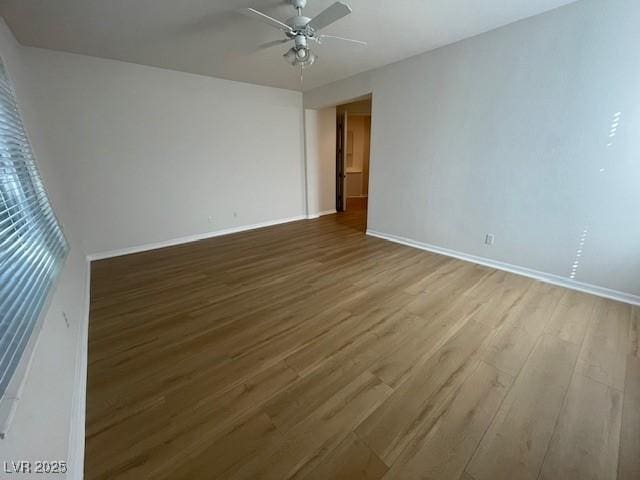 unfurnished room featuring ceiling fan, baseboards, and wood finished floors