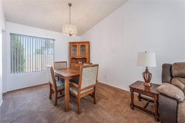 carpeted dining area with lofted ceiling and a chandelier