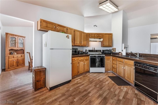 kitchen with lofted ceiling, range with gas cooktop, light wood-type flooring, white refrigerator, and dishwasher