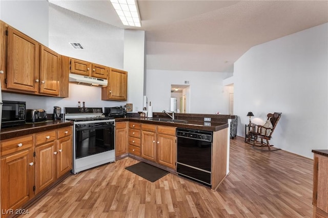 kitchen with sink, black appliances, kitchen peninsula, and light wood-type flooring