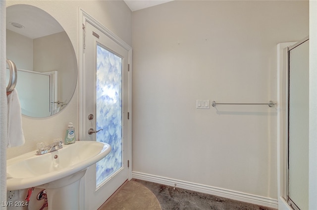 bathroom with tile patterned flooring, sink, and a shower with shower door