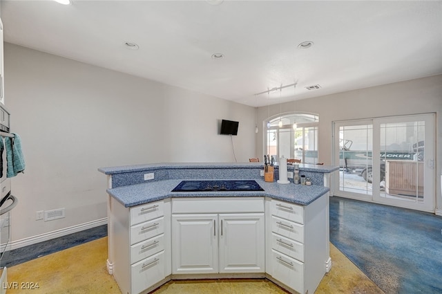 kitchen featuring white cabinetry, a center island, and black electric stovetop