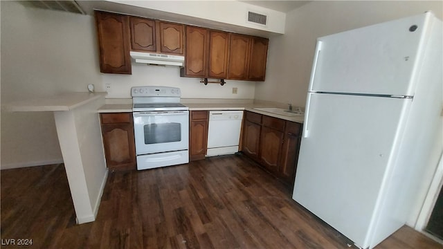 kitchen featuring white appliances, dark hardwood / wood-style floors, and sink