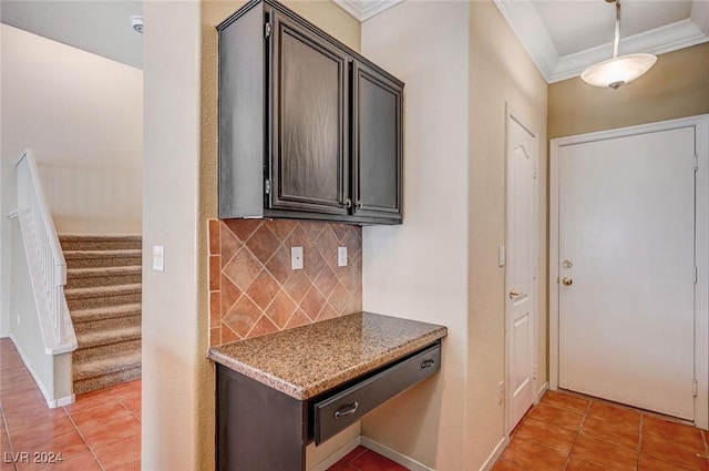 kitchen featuring tasteful backsplash, crown molding, dark brown cabinetry, and light tile patterned floors