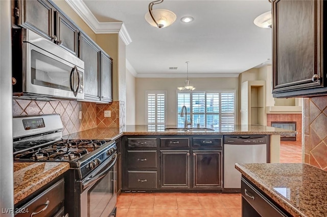 kitchen featuring dark brown cabinets, appliances with stainless steel finishes, pendant lighting, and a sink