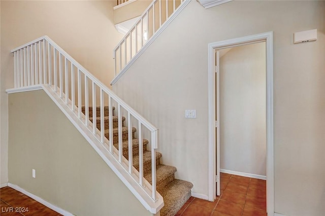 stairs with baseboards and tile patterned floors