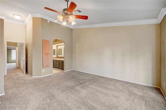 interior space featuring ornamental molding, arched walkways, light carpet, and baseboards