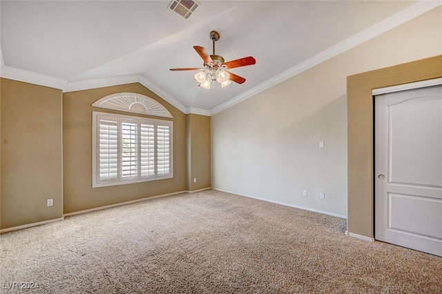 carpeted empty room featuring crown molding, lofted ceiling, visible vents, a ceiling fan, and baseboards