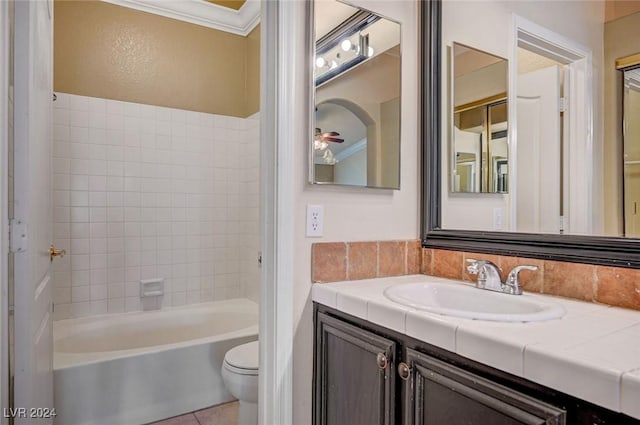 full bath with toilet, ornamental molding, tile patterned flooring, vanity, and washtub / shower combination