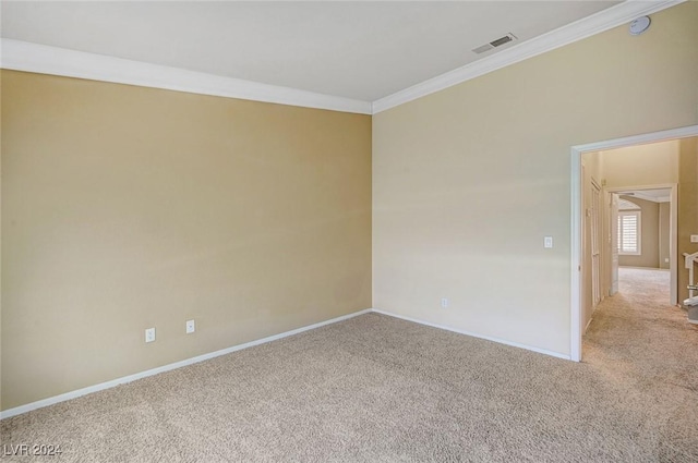 empty room featuring light carpet, baseboards, visible vents, and ornamental molding