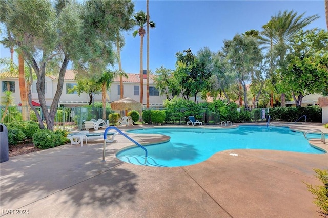 community pool featuring fence and a patio