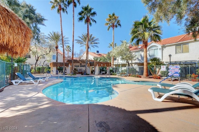 pool featuring fence and a patio