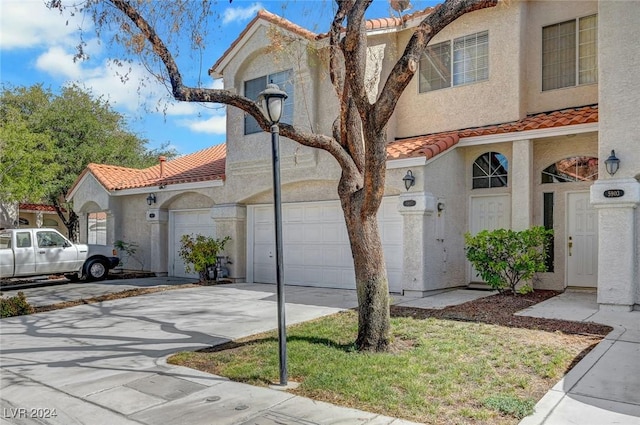 view of front of property with driveway, a tile roof, and stucco siding