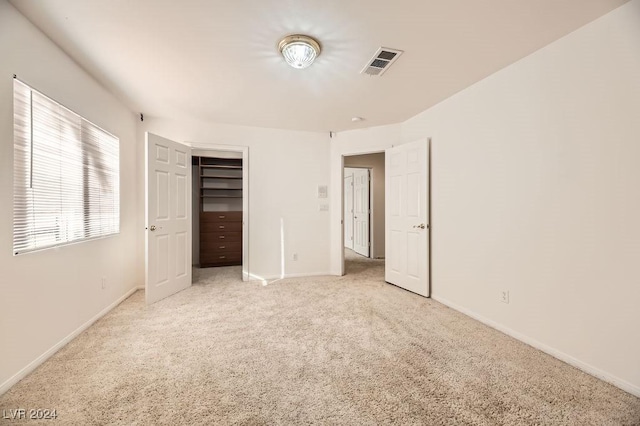 unfurnished bedroom featuring light colored carpet and a closet