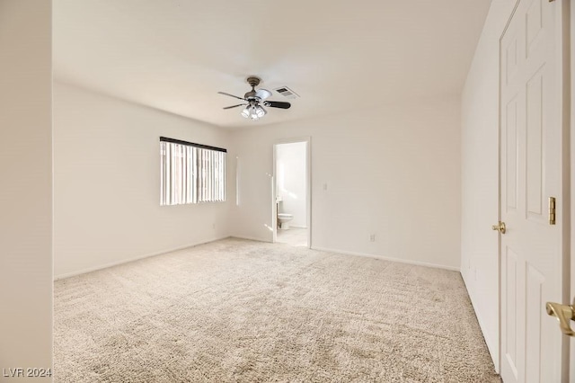 unfurnished bedroom with ceiling fan, light carpet, and ensuite bath