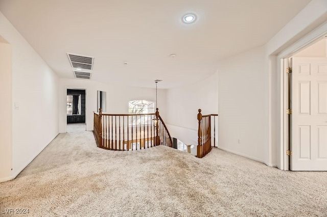 hallway featuring light colored carpet