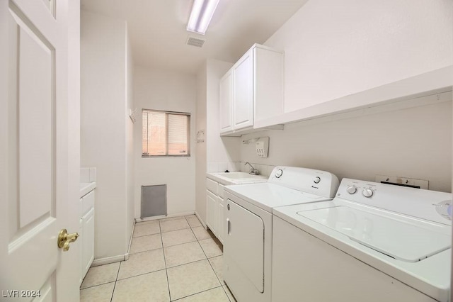 laundry room featuring washer and clothes dryer, cabinets, light tile patterned floors, and sink