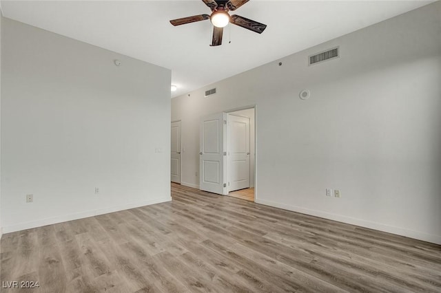 spare room with visible vents, light wood-style flooring, and baseboards