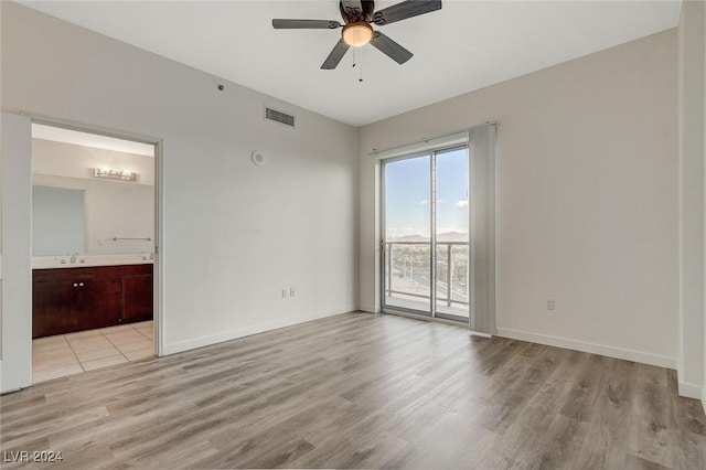 spare room featuring baseboards, ceiling fan, visible vents, and light wood-style floors