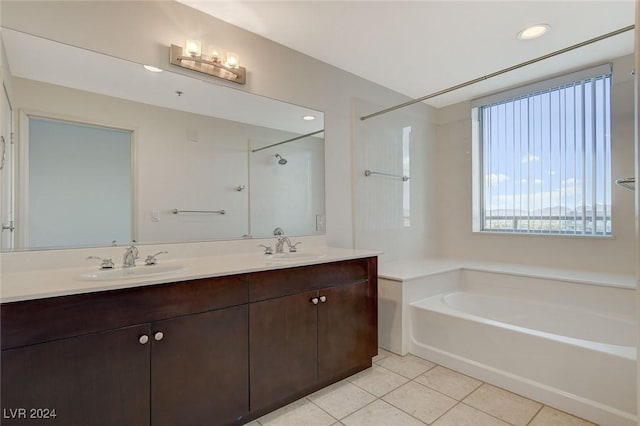 full bathroom with double vanity, a garden tub, a sink, and tile patterned floors