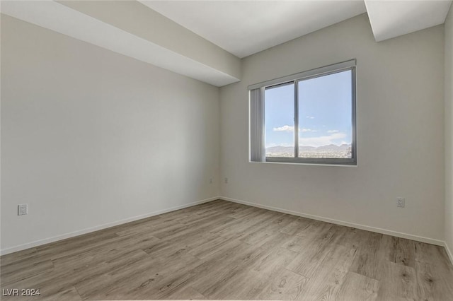 empty room featuring light wood-style flooring and baseboards