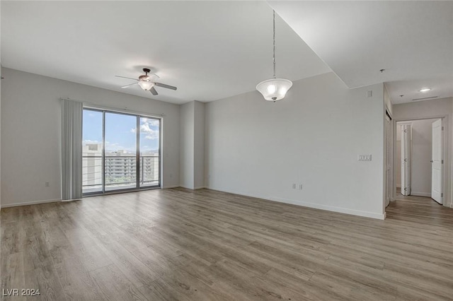 unfurnished room with a ceiling fan, baseboards, and wood finished floors