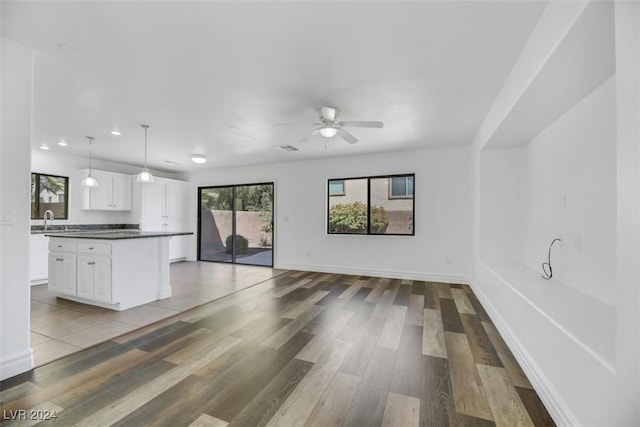 kitchen with pendant lighting, ceiling fan, light wood-type flooring, and white cabinetry