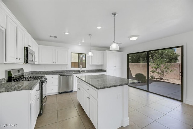 kitchen featuring a center island, white cabinetry, stainless steel appliances, and a wealth of natural light