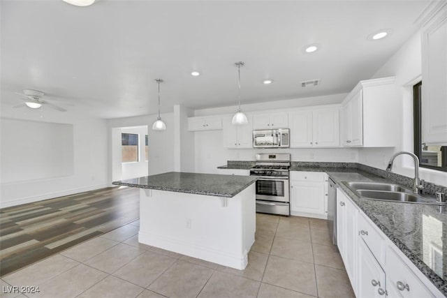 kitchen with white cabinets, light wood-type flooring, sink, and appliances with stainless steel finishes