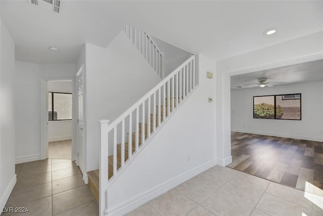 stairs featuring hardwood / wood-style flooring, ceiling fan, and a wealth of natural light