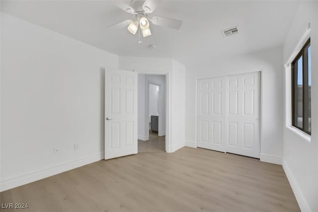 unfurnished bedroom featuring ceiling fan, a closet, and light hardwood / wood-style flooring