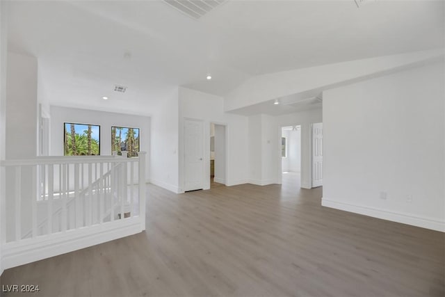 empty room with hardwood / wood-style floors and lofted ceiling