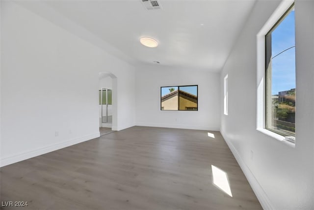 spare room with lofted ceiling and dark wood-type flooring