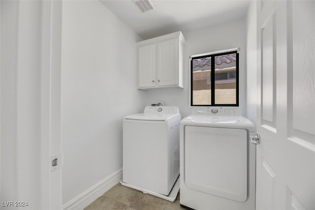 washroom featuring cabinets, separate washer and dryer, and light tile patterned floors