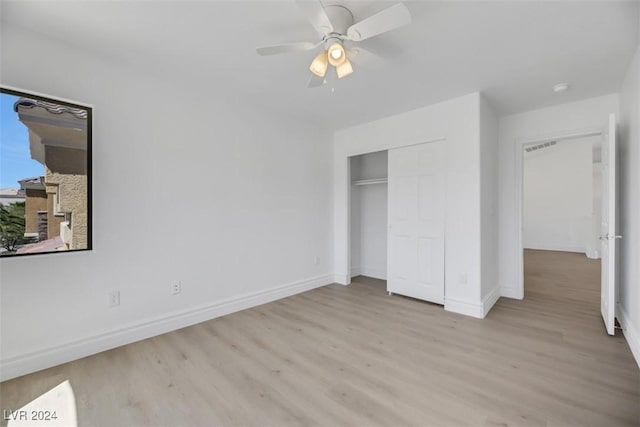 unfurnished bedroom featuring light wood-type flooring, a closet, and ceiling fan