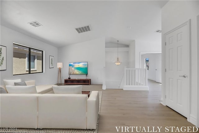 living room featuring hardwood / wood-style flooring and vaulted ceiling