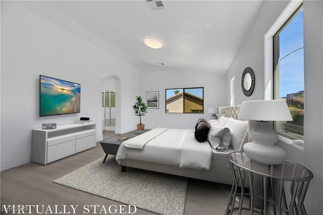 bedroom featuring light wood-type flooring and vaulted ceiling