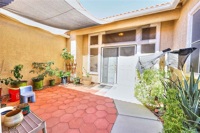 property entrance featuring a patio area and stucco siding