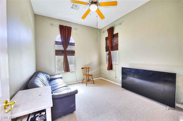 living room with light colored carpet, visible vents, ceiling fan, and baseboards