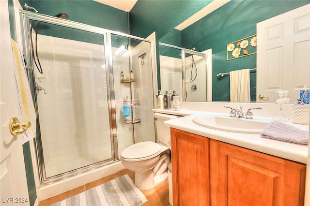 bathroom featuring toilet, a shower stall, and vanity