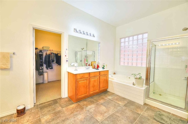 full bathroom featuring a garden tub, a spacious closet, a shower stall, and vanity